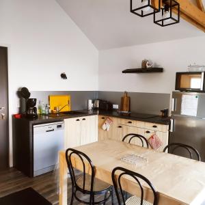 cocina con mesa y sillas en una habitación en Le Bas Champ, en Favières