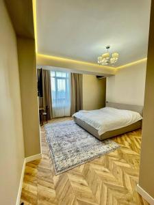 um quarto com uma cama e um tapete no chão em Designer apartment near the Gum shopping center em Bishkek