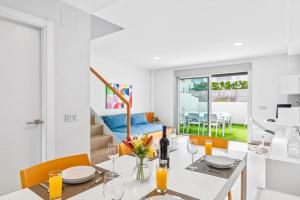 a white dining room with a table and chairs at MEDANO4YOU Bahia Medano Surf in El Médano