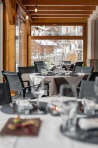 une salle à manger avec des tables, des chaises et des verres à vin dans l'établissement Agritur Il Tempo delle Mele, à Caldes