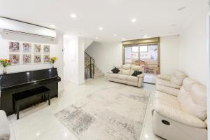 een woonkamer met een piano en een bank bij Chateau Gabriel Luxury 6 BR Villa with Heated Pool in Bet Shemesh