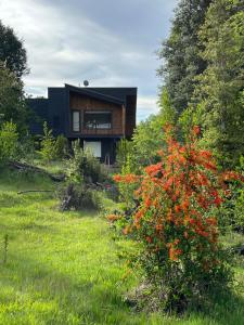 una casa en medio de un campo con flores en Casa Condominio Pucon Villarrica, en Molco