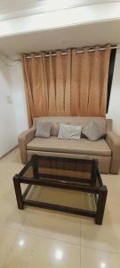 un divano in soggiorno con tavolino di Stay in elegant 1bhk a Navi Mumbai