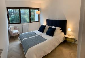 a bedroom with a large bed with blue pillows at Magnifique Appartement, 3 min de Paris in Levallois-Perret
