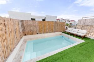 a swimming pool in a yard next to a wooden fence at Chateau Gabriel Luxury 6 BR Villa with Heated Pool in Beit Shemesh