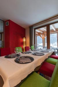 une salle à manger avec une grande table et des chaises vertes dans l'établissement Agritur Il Tempo delle Mele, à Caldes