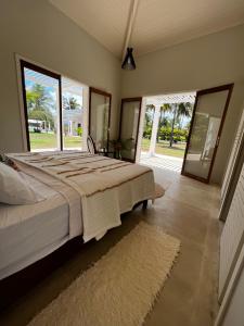 a bedroom with a large bed and a large window at Maracajau Luxury Home - Villa-Mar-a-Villa in Maxaranguape