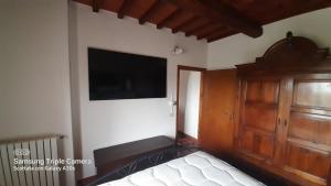 1 dormitorio con 1 cama y TV de pantalla plana en Aietta Tuscan Holidays, en Montaione