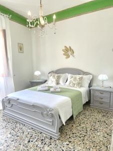 a bedroom with a large white bed and two tables at A Casa di Ale in Sorso