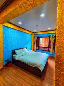 1 dormitorio con 1 cama grande y pared azul en SN Guest House en Bhaktapur