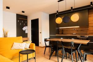 a kitchen and living room with a yellow couch and a table at My Tarvisio home in Tarvisio