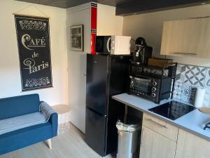 cocina con nevera negra y microondas en Bel appartement cosy centre Veules-Les-Roses Parking privé WIFi, en Veules-les-Roses