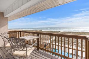 ein Balkon mit Tisch und Stühlen und der Strand in der Unterkunft Breezeway in Navarre