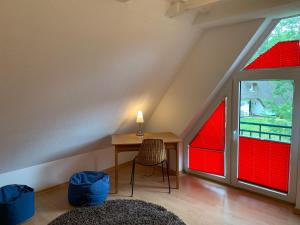 um quarto com janelas vermelhas e uma secretária com um candeeiro em Haus-Friesenstrasse-Whg-17 em Sankt Peter-Ording