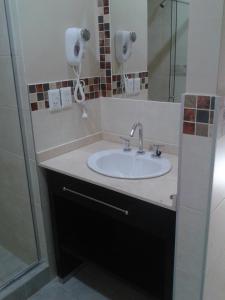 een badkamer met een wastafel en een douche bij ARAMI HOTEL & LODGE in Puerto Iguazú