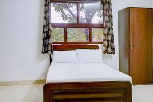 Flagship Hotel Lotus Inn في فاراناسي: سرير في غرفة مع نافذة
