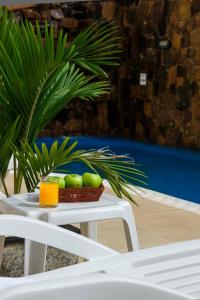 a basket of fruit on a table next to a plant at ARAMI HOTEL & LODGE in Puerto Iguazú