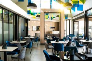 a restaurant with tables and chairs and windows at Bellamare in Summerstrand