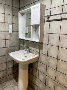 a bathroom with a white sink and a mirror at استديو غرفه بأثاث مريح in Al Madinah