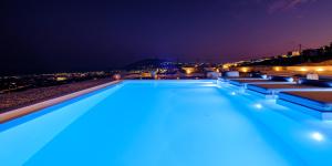 una piscina por la noche con vistas en Terra Blanca Suites en Imerovigli
