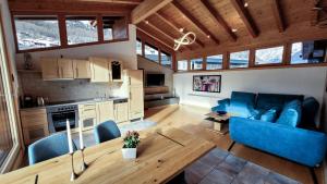 a living room with a blue couch and a table at Hotel Garni Birkenhof in Sölden