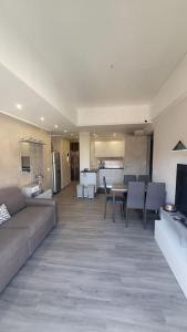 ein Wohnzimmer mit einem Sofa und einem Tisch sowie eine Küche in der Unterkunft Modern flat in the Centre in Rapallo