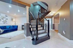 escalera de caracol en una sala de estar con sofá azul en 5 amazing bedrooms in suburban delight!, en Pickering
