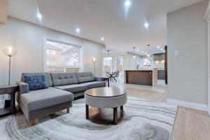 ein Wohnzimmer mit einem Sofa und einem Tisch in der Unterkunft 5 amazing bedrooms in suburban delight! in Pickering
