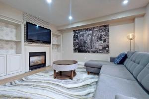 sala de estar con sofá y TV en 5 amazing bedrooms in suburban delight!, en Pickering