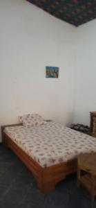 ein Schlafzimmer mit einem Bett in einem Zimmer in der Unterkunft Chez John et Élisa in Ndangane