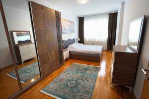 - une chambre avec un lit et un miroir dans l'établissement EMEOS Apartments, à Peje