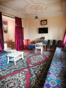 Grand Atlas Guesthouse 44 km from Marrakech في مراكش: غرفة معيشة مع أريكة وطاولة