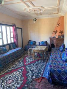 Grand Atlas Guesthouse 44 km from Marrakech في مراكش: غرفة مع أريكة وطاولة في غرفة