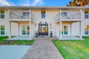 a white house with a door and a balcony at Corpus Christi's Charmer in Corpus Christi