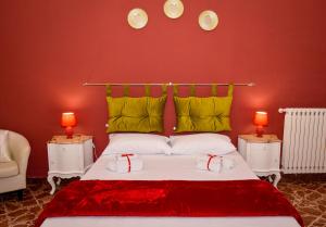 a bedroom with a bed with red walls and two lamps at Alba e i Mori in Palermo