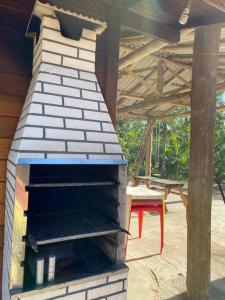 an outdoor brick oven in a patio with a table at Sítio da Paz - Pinheira Sc in Palhoça