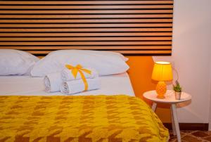a bedroom with a bed with a yellow blanket and a table at Alba e i Mori in Palermo
