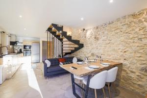 a kitchen and living room with a stone wall at L'Authentique in Le Sappey-en-Chartreuse