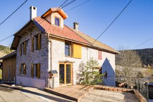 a small brick house with a wooden deck at L'Authentique in Le Sappey-en-Chartreuse