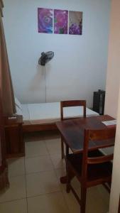 Pokój z ławką ze stołem i telefonem w obiekcie RAOOF HOTEL w mieście Mahajanga