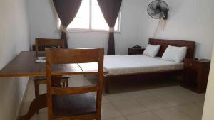 sypialnia z łóżkiem, biurkiem i oknem w obiekcie RAOOF HOTEL w mieście Mahajanga