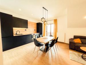 una cucina e una sala da pranzo con tavolo e sedie di Villa verde leisure apartment a Tarvisio