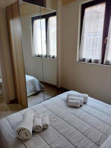 - une chambre avec un grand lit et des serviettes dans l'établissement Appartamento L'ANGOLO, à San Severo