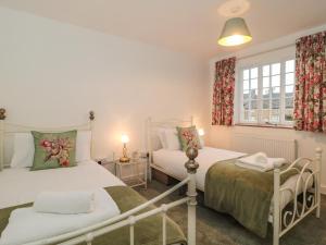 a bedroom with two beds and a window at Two Towers Cottage in Montacute