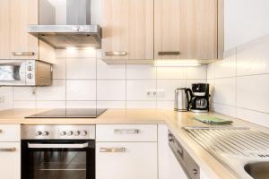 a kitchen with white cabinets and a stove top oven at Haus Alvier by A-Appartments in Brand