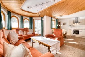 ein Wohnzimmer mit orangefarbenen Möbeln und einer Holzdecke in der Unterkunft Haus Alvier by A-Appartments in Brand