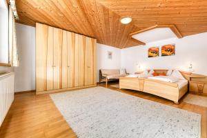 a bedroom with a bed and a couch and wooden ceilings at Haus Alvier by A-Appartments in Brand +29 photos