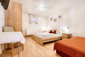 a bedroom with two beds and a table and chairs at Haus Alvier by A-Appartments in Brand