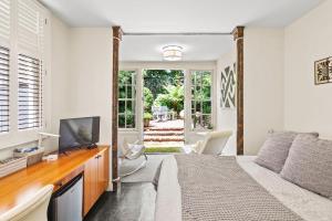 a bedroom with a bed and a television and a patio at Pacific Heights Victorian Garden Suite in San Francisco