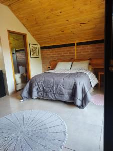 een slaapkamer met een bed en een houten plafond bij Chalé Sítio São José in Santo Antônio do Pinhal